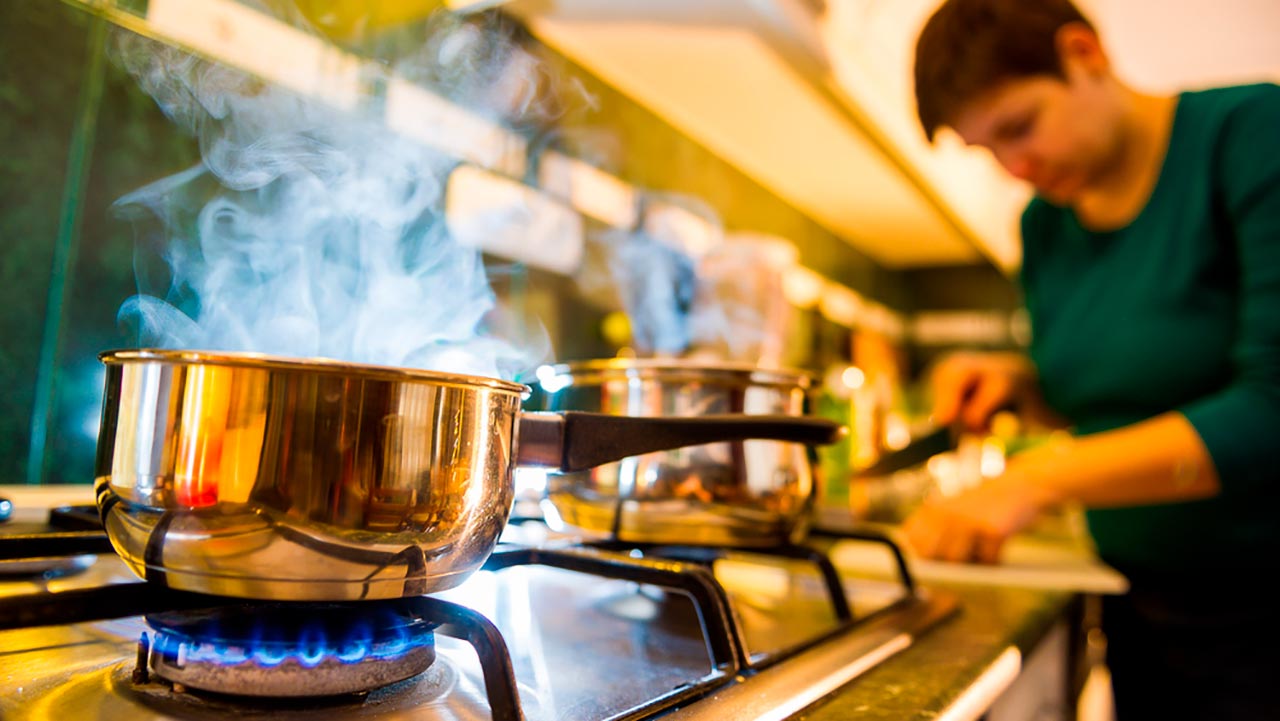 Mulher cozinhando no fogo do fogão